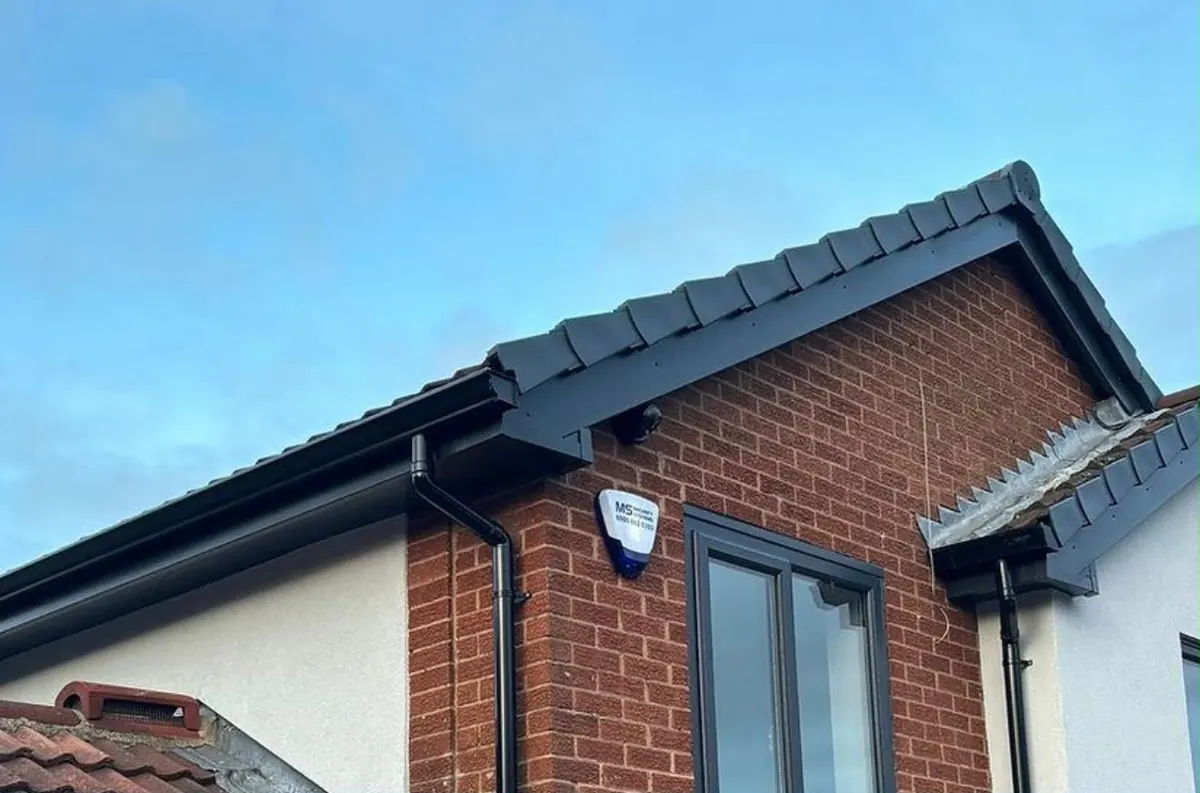 Black gutter and fascia fitted along a brick gable