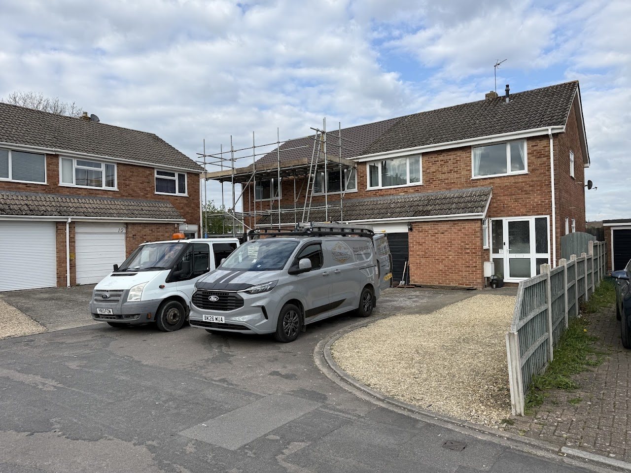 Two Yellowstone vans outside a semi-detached house with scaffolding