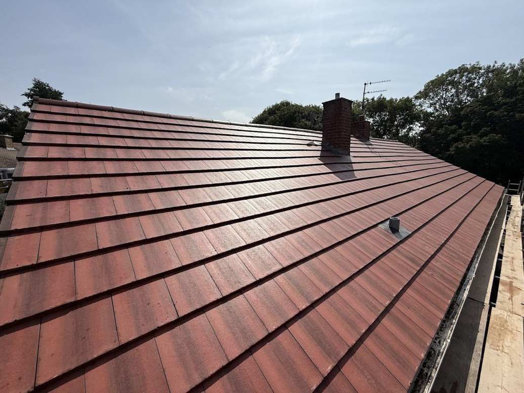 Newly finished red concrete tile roof with chimney