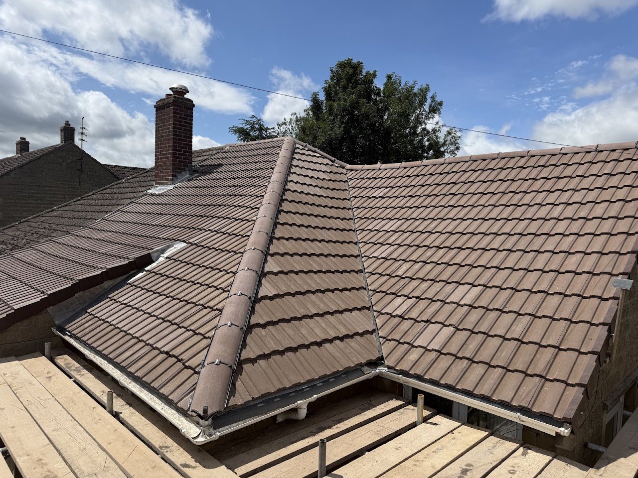 New brown tile roof with a hip and ridge tiles