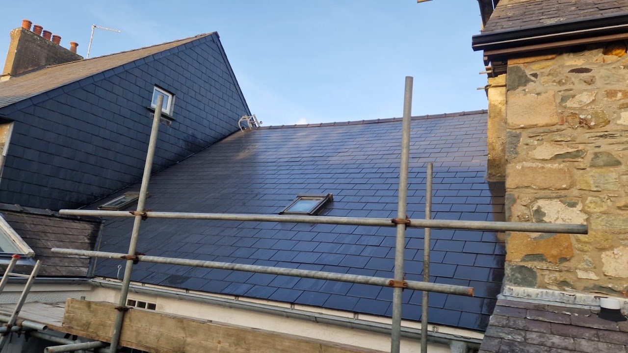 New slate roof with a rooflight beside a stone gable